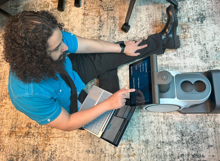 Vista Supports staff member configuring assistive technology using a tablet and laptop to support accessible communication solutions